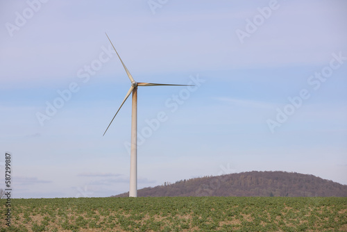 Single tower, nacelle and rotor blades of a wind turbine with oil running down the tower and the rotor blates in front off the sky.