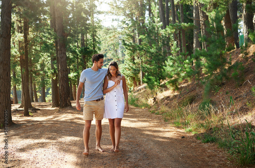Couple take a walk in forest, nature and travel, relax together with hug outdoor, love with care and bonding. Summer, holiday with man and woman strolling in countryside with relationship and trust