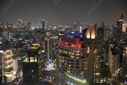 Spectacular view over the city lights of Bankok in Thailand at night photographed from a rooftop bar. photo