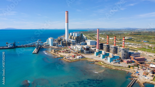 Aerial view on a large thermal power plant built along the coasts of the Mediterranean sea in Civitavecchia, near Rome, Italy. In the background the islands of the Tuscan archipelago.