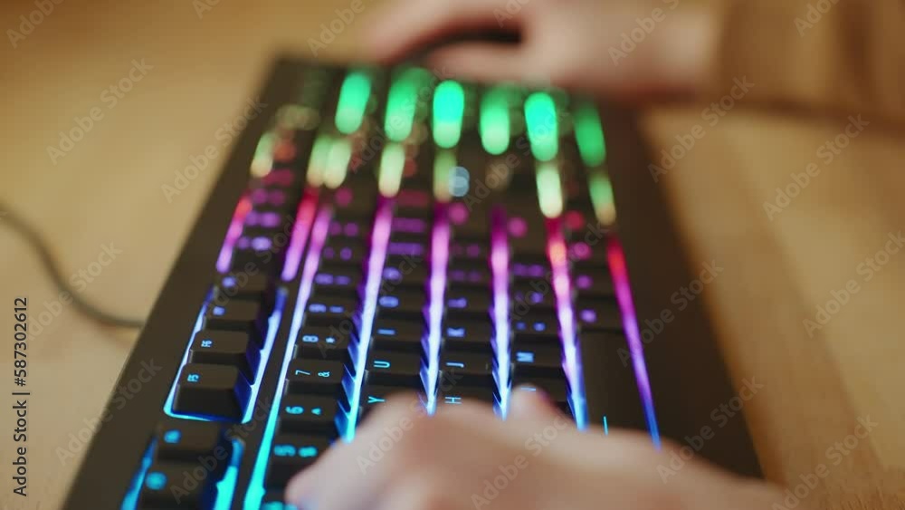 Player Uses Gaming Keyboard of bokeh light bulbs garlands. Young Gamer Plays Video Game Hands Close up Typing on Computer Keyboard in Neon Lighting. Guy teenager. Cybersportsman. Cyberspace Player Uses Gaming Keyboard of bokeh light bulbs garlands. Young Gamer Plays Video Game Hands Close up Typing on Computer Keyboard in Neon Lighting. Guy teenager. Cybersportsman. Cyberspace
