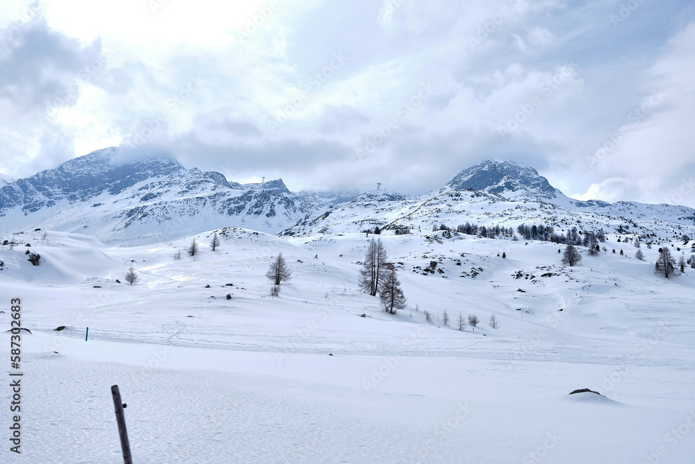 Bernina mountain pass. The famous red train is crossing the white lake. Amazing landscape of the Switzerland land. Famous destination and tourists attraction