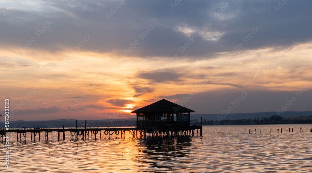 Old abandoned wooden fisherman building, sunset at the pier 
