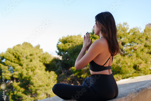 Cheerful young girl does yoga poses outdoors © MiguelZare