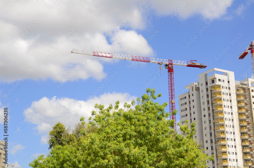 Construction site, construction crane. New building in Israel. Concept: real estate agency, apartment on credit, real estate investment. Modern white residential building Construction site, construction crane. New building in Israel. Concept: real estate agency, apartment on credit, real estate investment. Modern white residential building
