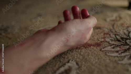 Close up of white male murdered hand falling to the floor