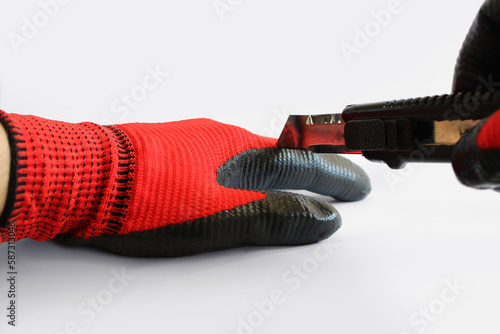 Cut resistant work gloves. Utility knife trying to cut work glove on white background. photo