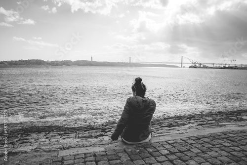 imagen de soledad con una chica y el puente rojo de lisboa en el fondo  photo