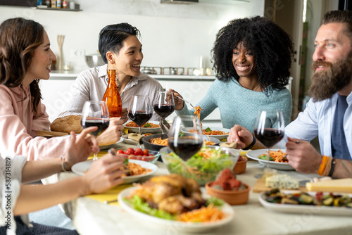 Multiracial friends gathering having Italian food together, focus on African woman smile