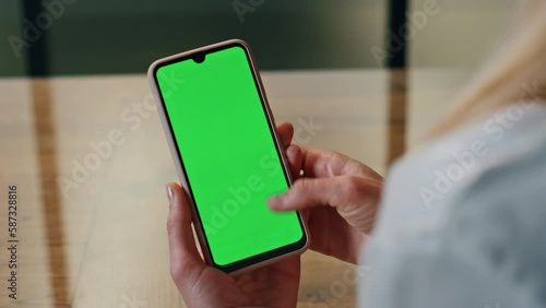Woman hand scrolling green phone screen indoor closeup. Lady reading cellphone