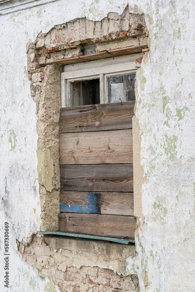 A boarded up house window.