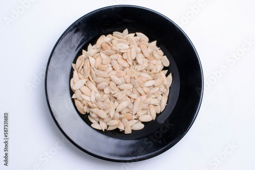 Musk melon magez seeds on plate with white background. photo