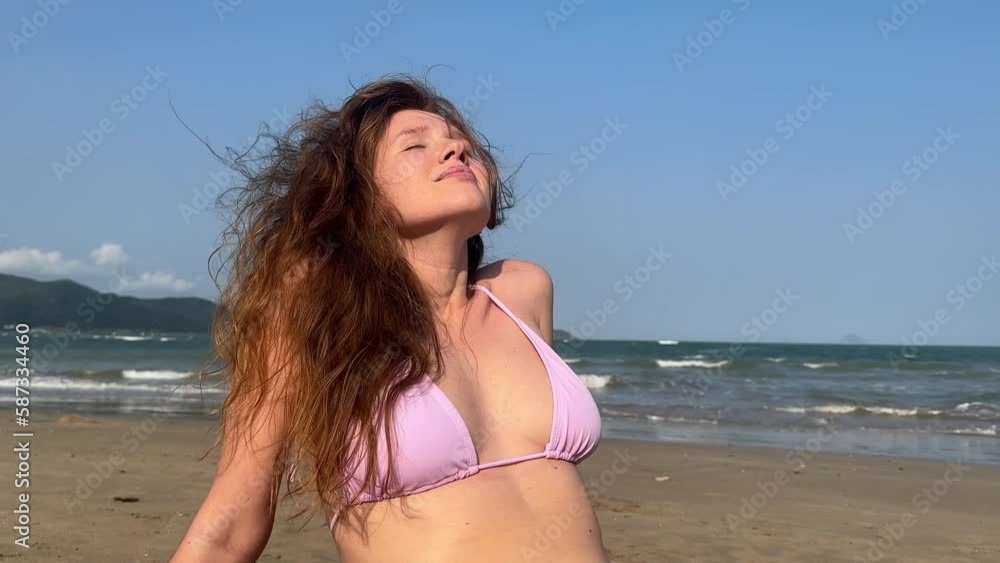 young girl on the sea is resting in summer in windy weather in a swimsuit, vacation in Asia young girl on the sea is resting in summer in windy weather in a swimsuit, vacation in Asia