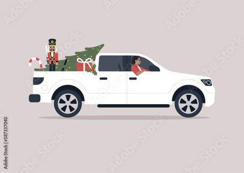 A young driver in a pickup truck delivering Christmas decorations