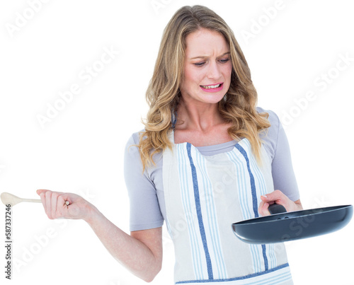 Woman holding frying pan and wooden spoon 