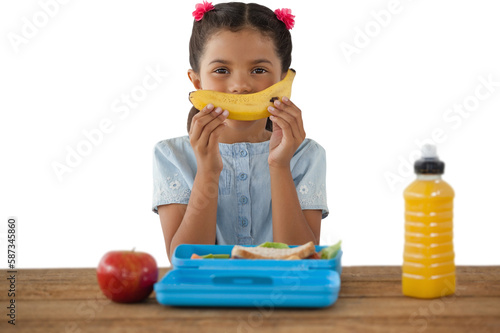 Girl holding banana at table