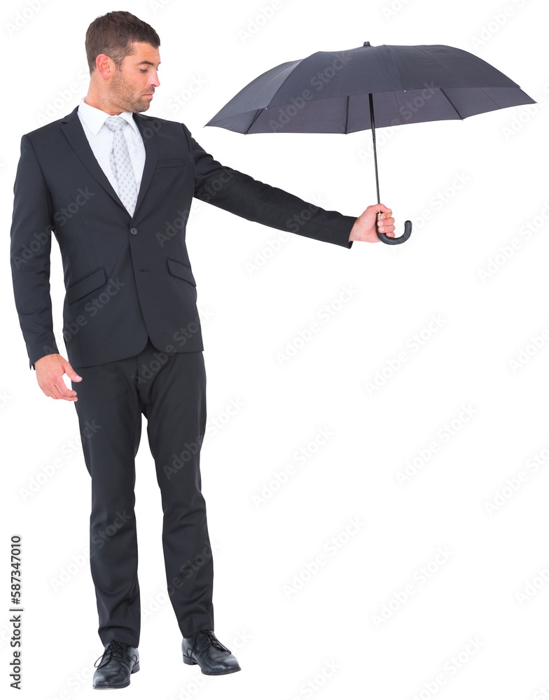 Businessman holding black umbrella beside him Businessman holding black umbrella beside him