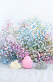 decorative Easter bunnies and egg with colorful flowers close up on abstract blurred light background. Easter holiday, Ostara concept. festive composition for spring season. design for greeting card.