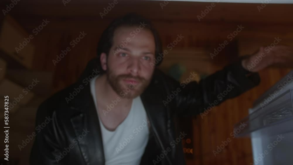 Handsome Man with Long Hair and Black Jacket Opens Refrigerator Door to Grab a Snack Handsome Man with Long Hair and Black Jacket Opens Refrigerator Door to Grab a Snack