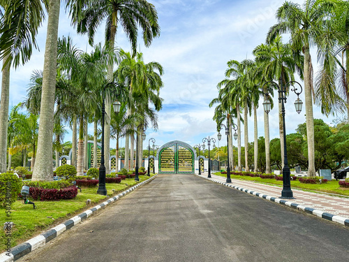 Bild auf Leinwand gate and road to a mosque in Brunei Darussalam with blue sky and white clouds in