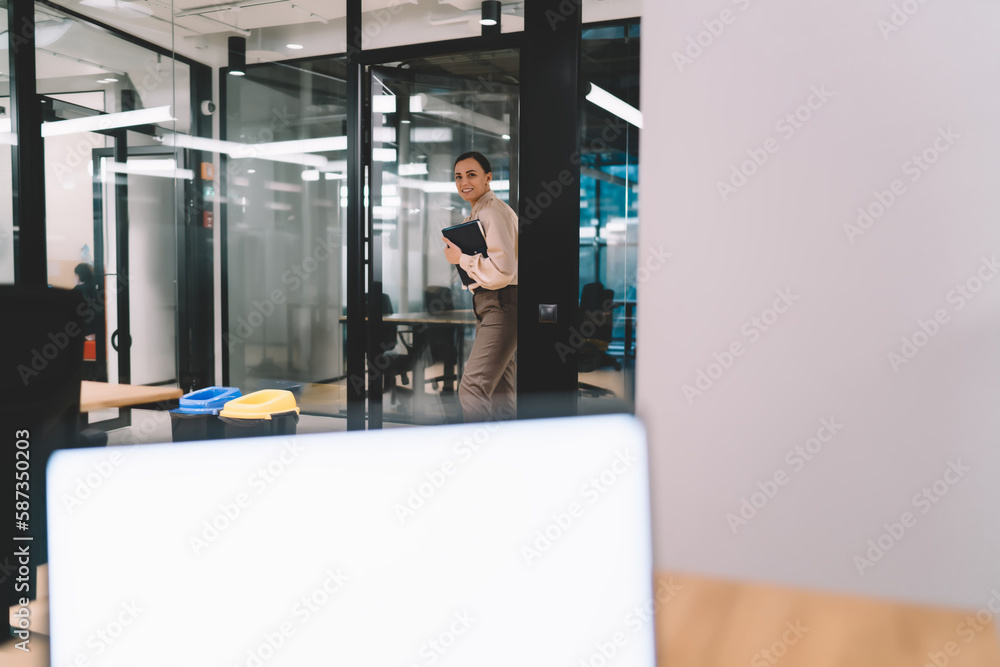 Woman standing with planner in hand in office Woman standing with planner in hand in office