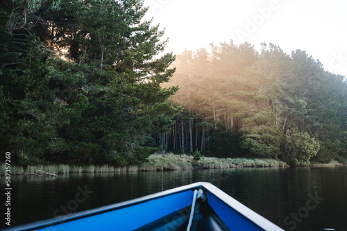 Sunbeam passing through the trees to the river, seen from inside a boat point of view at early morning. POV photograph