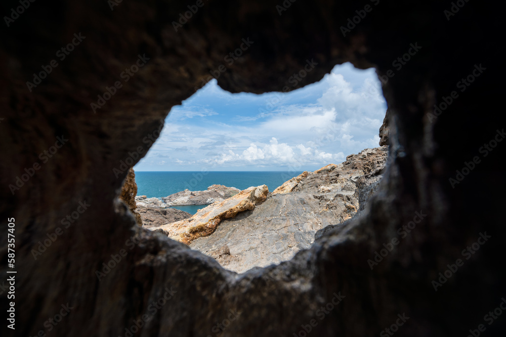 View of the rocky cliff of Cap de Creus and the Mediterranean Sea through the opening of the cave on a sunny day - June 2018 - Catalonia, Spain