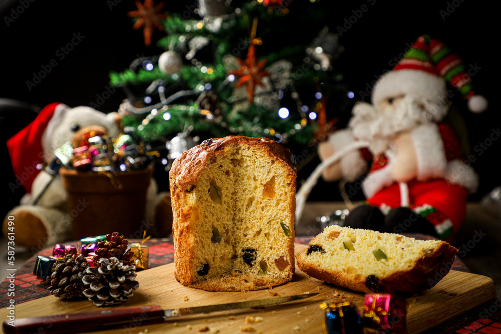 Christmas panettone with Santa Claus and illuminated Christmas tree in the background accompanied by a pine cone Christmas panettone with Santa Claus and illuminated Christmas tree in the background accompanied by a pine cone