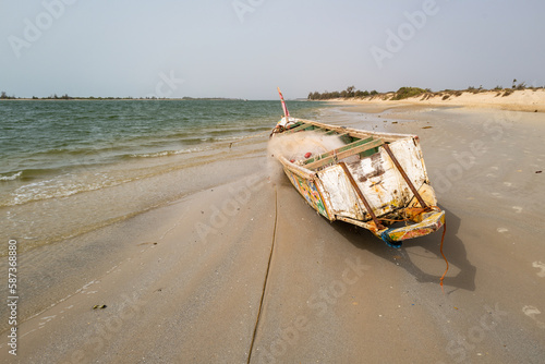 une pirogue peinte échouée sur la plage au Sénégal en Afrique photo