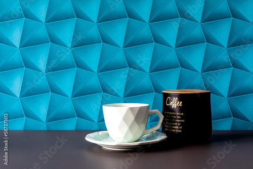 A background with blue wallpaper - colorful space. Morning coffee in an elegant style. Coffee on the table - minimalist accessories. White cups and coffee container - simplicity in an elegant style.