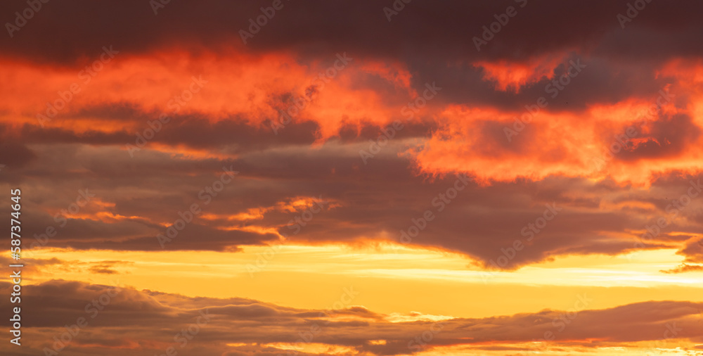 Beautiful bright orange sunset sky with dramatic clouds. Sunset sky with clouds background.