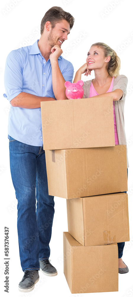 Attractive young couple leaning on boxes with piggy bank Attractive young couple leaning on boxes with piggy bank