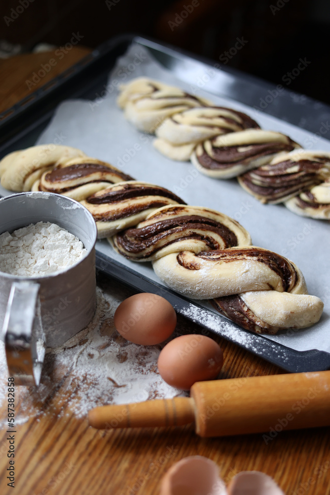 braid with chocolate, raw dough for a bun with chocolate. Freshly baked chocolate swirl pastry - babka. Baker make buns from dough with poppy and chocolate filling. Cooking twisted pie. Top view braid with chocolate, raw dough for a bun with chocolate. Freshly baked chocolate swirl pastry - babka. Baker make buns from dough with poppy and chocolate filling. Cooking twisted pie. Top view