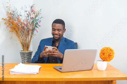 Cuadro en lienzo Smiling mature businessman holding using phone and laptop sitting in office