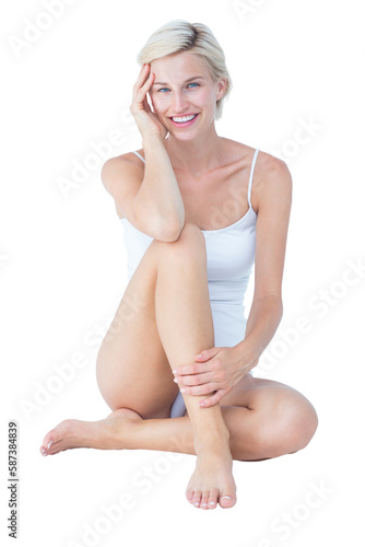 Gorgeous blonde sitting on the floor smiling at camera 