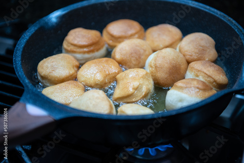 Frying homemade donuts in the kitchen, sweet dessert.