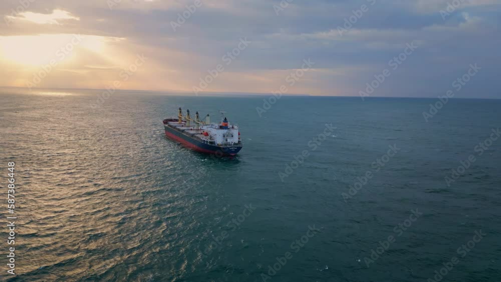 Bulk carrier ship sailing to sunset. Drone view vessel floating in dark ocean. Bulk carrier ship sailing to sunset. Drone view vessel floating in dark ocean.