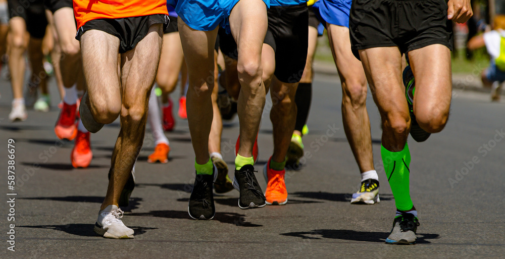 close-up legs runners running sport marathon, male jogging race in asphalt road, athletics competition close-up legs runners running sport marathon, male jogging race in asphalt road, athletics competition