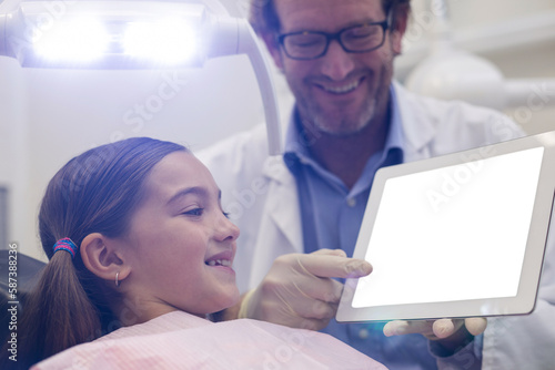Dentist showing digital tablet to young patient