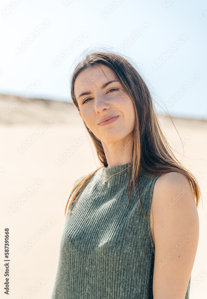 Charming woman in dress standing on sandy beach Charming woman in dress standing on sandy beach