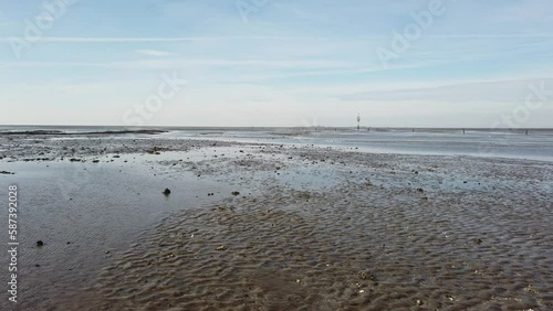 Rettungsbake und Priel im Wattenmeer bei Ebbe, Nordsee, Schwenk photo