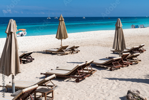 Sun loungers and chairs with umbrellas on the beach in Zanzibar, Tanzania