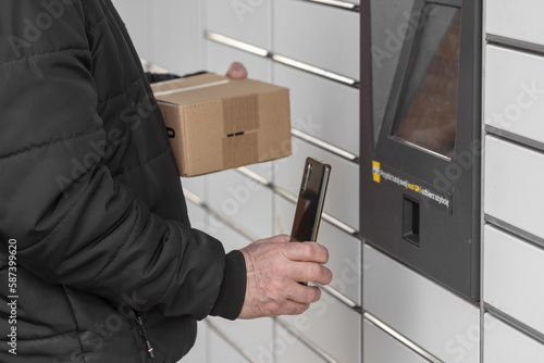 Old man with smartphone entering QR code to open shopping locker. Caption: Read the QR code here and pick it up faster. photo