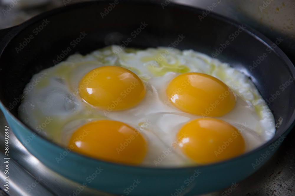 Duck eggs being fried on a metal pan Duck eggs being fried on a metal pan