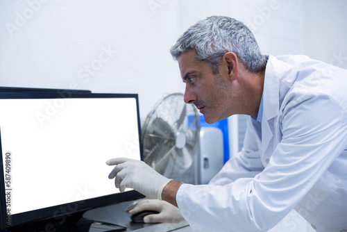 Thoughtful dentist examining x-ray on monitor
