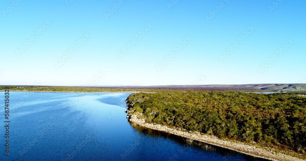Scenic view of river by grassy hill