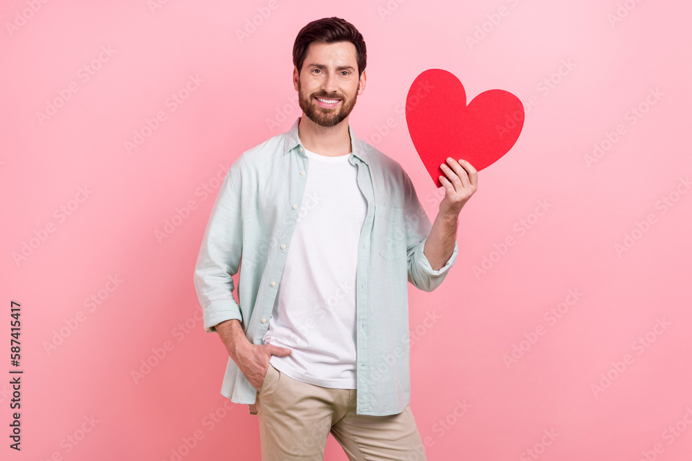 Photo portrait of attractive young man cheerful hold red big postcard present wear trendy blue outfit isolated on pink color background Photo portrait of attractive young man cheerful hold red big postcard present wear trendy blue outfit isolated on pink color background