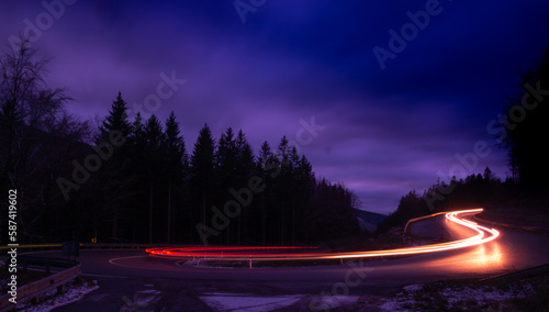 Car light lines on a mountain asphalt road in the evening © Jansk