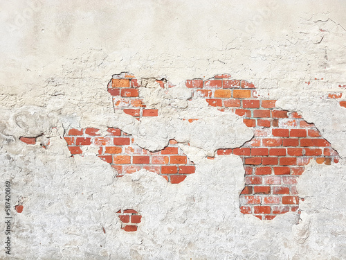 Old brick wall with peeling plaster grunge background concrete stucco texture.