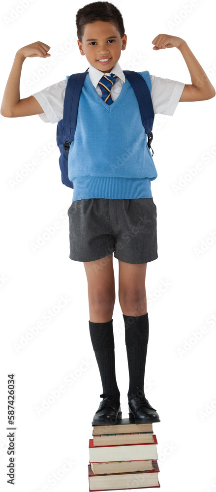 Portrait of schoolboy flexing muscles while standing on books Portrait of schoolboy flexing muscles while standing on books